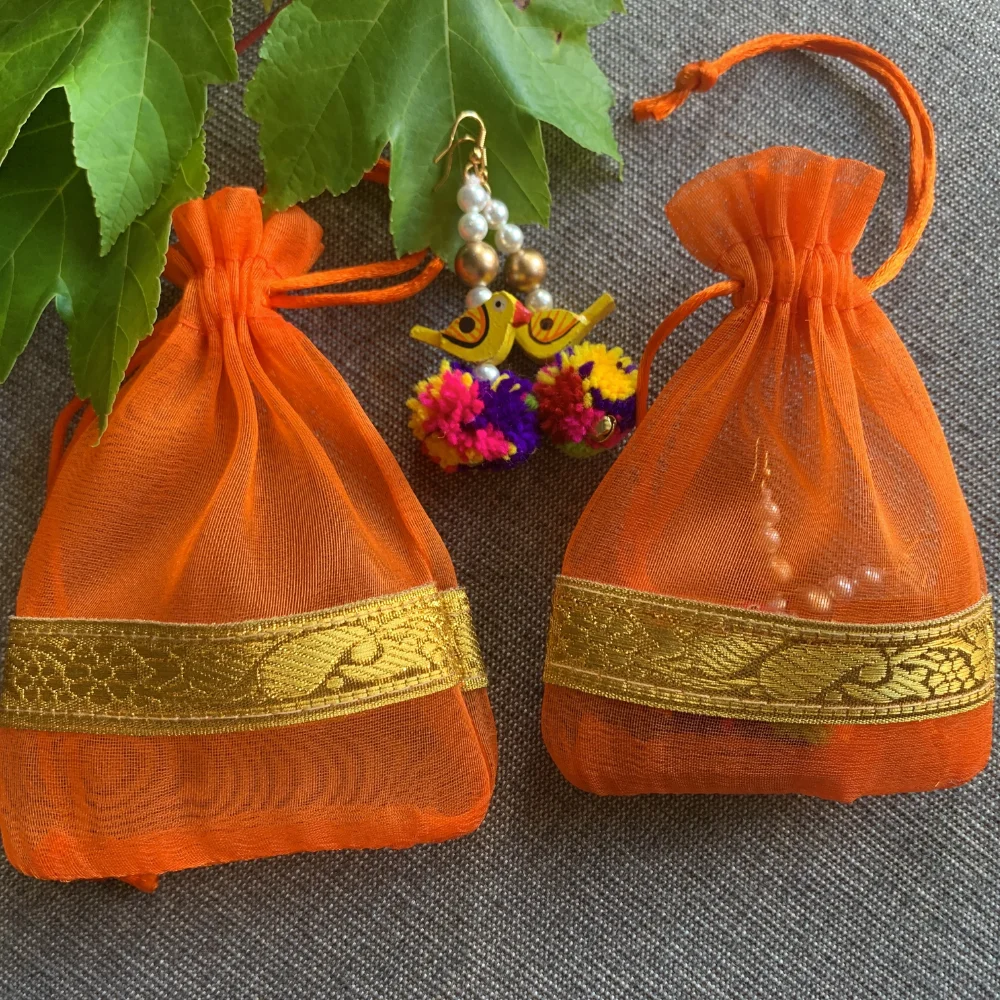 Orange color pouch with multi color pom pom earrings